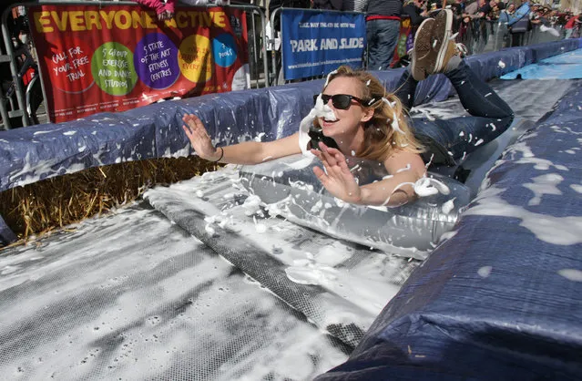 A participant on a lilo slides down a giant water slide that has been installed down Park Street on May 4, 2014 in Bristol, England. (Photo by Matt Cardy/Getty Images)