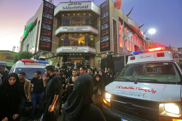 People gather outside a hospital while ambulances bring injured people after a walkway collapsed and set off a stampede as thousands of Shiite Muslims marked one of the most solemn holy days of the year in the holy city of Karbala, Iraq, Tuesday, September 10, 2019. Officials say at least 31 people have died and around 100 others were injured in the chaos Tuesday, which occurred toward the end of the Ashoura procession, causing panic and a stampede, according to two officials. (Photo by Anmar Khalil/AP Photo)