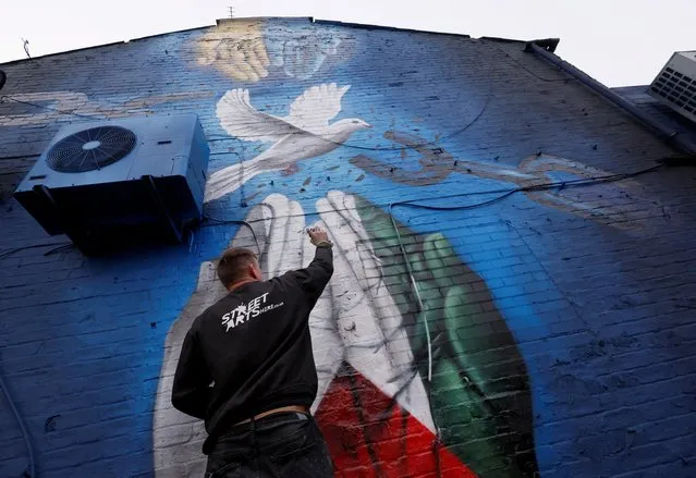 Street artist Nathan Murdoch creates an artwork in support of Ukraine and Palestine, in Peterborough, Britain, March 15, 2022. (Photo by Andrew Couldridge/Reuters)