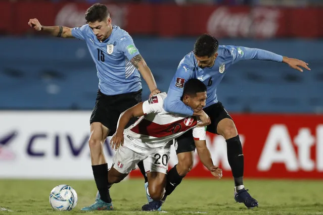 Peru's Edison Flores, center, fight for the ball with Uruguay's Rodrigo Bentancur, right, and FedericoValverde during a qualifying soccer match for the FIFA World Cup Qatar 2022 in Montevideo, Uruguay, March 24, 2022. (Photo by Matilde Campodonico/AP Photo/Pool)