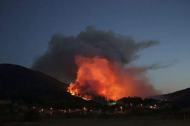 A photograph made available on 23 July 2015 a general view of a fire that broke out in the village of Padron, Galicia, northwestern Spain, late 22 July 2015. The fire was brought under control in the early hours of 23 July 2015. Early reports state that some 40 hectares of forest were affected by the fire. (Photo by EPA/Sxenick)