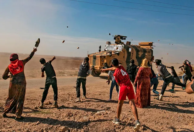Syrians throw stones towards Turkish military vehicles during a Turkish-Russian army patrol near the town of Darbasiyah in Syria's northeastern Hasakeh province along the Syria-Turkey border on November 11, 2019. (Photo by Delil Souleiman/AFP Photo)