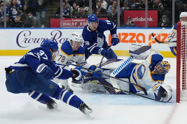 Buffalo Sabres goaltender Craig Anderson (41) stretches to make a save in front of Toronto Maple Leafs defenseman Timothy Liljegren (37) and Sabres defenseman Jacob Bryson (78) during the second period of an NHL hockey game Tuesday, April 12, 2022, in Toronto. (Photo by Nathan Denette/The Canadian Press via AP Photo)