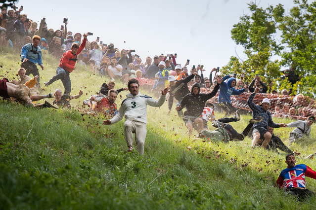 Hundreds of spectators gather at Cooper's Hill in Gloucestershire, UK on May 29, 2023 to see the annual cheese rolling event. For over 200 years, the annual cheese rolling festival has been an integral part of Gloucester culture. Each year daredevil participants hurl themselves down the 300 yards Cooper's hill to lay claim to a wheel of cheese and bragging rights. Attracting people from all over the world who are determined to keep the world-famous tradition alive, Cooper's Hill has played host to the Cheese Rolling extravaganza since the 1800s – with the event traditionally falling on the late May bank holiday Monday. (Photo by Lee Thomas/The Times)