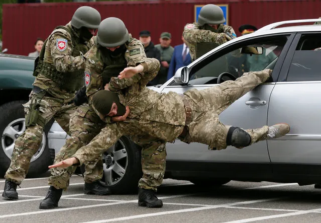 Members of the newly created special police team KORD take part in a demonstration as part of a ceremony to commemorate finishing their training course at a base outside Kiev, Ukraine, May 6, 2016. Picture taken May 6, 2016. (Photo by Valentyn Ogirenko/Reuters)