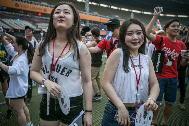 South Korean women with their faces painted with Korean flag's Yin and Yang mark (taegeuk) dance to electronic music during the Ultra Music Festival Korea at Olympic Stadium on June 10, 2016 in Seoul, South Korea. (Photo by Jean Chung/Getty Images)