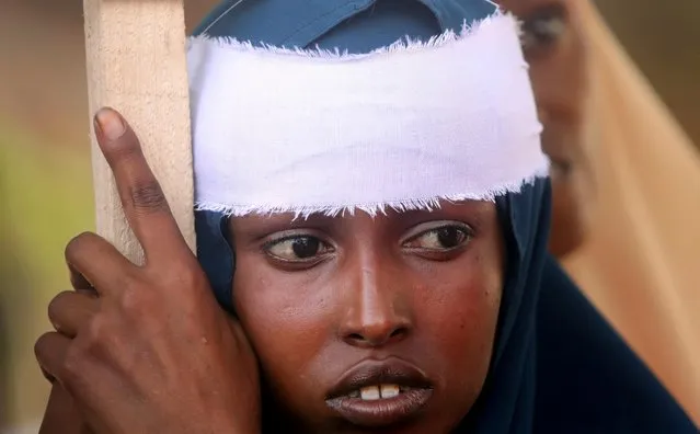 A Somali woman wears a white band on her head as she participates in a protest against al-Shabaab militia over the car bomb explosion at the Afgoye junction, outside the General Kahiye Police Academy in Mogadishu, Somalia on January 2, 2020. (Photo by Feisal Omar/Reuters)