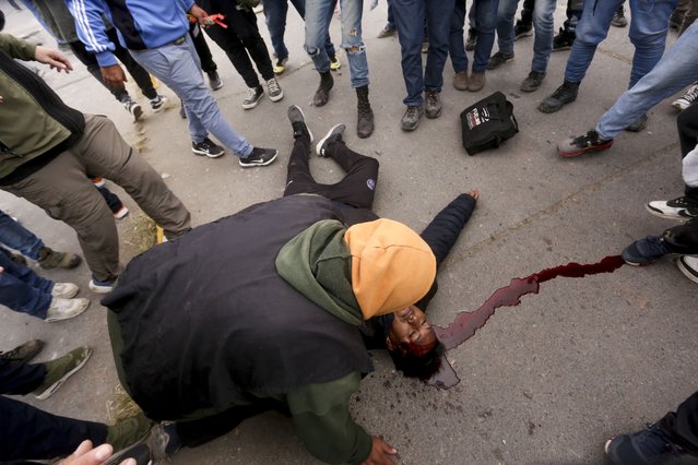 Protesters assist a demonstrator injured during clashes between police and protesters in San Salvador de Jujuy, Argentina, Tuesday, June 20, 2023. Protests have erupted throughout the province in response to a recently approved provincial constitutional reform that critics argue restricts the rights of social protest. (Photo by Juan Burgos/AP Photo)