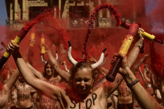 Demonstrators brake “banderillas” with red dust during a protest against bullfighting in front of the City Hall a day before of the San Fermin festival, in Pamplona, northern Spain, Wednesday, July 5, 2017. The festival will begin on July 6 with the “txupinazo” opening ceremony, with people participating in bull runs, music and dance, through the old city. (Photo by Alvaro Barrientos/AP Photo)