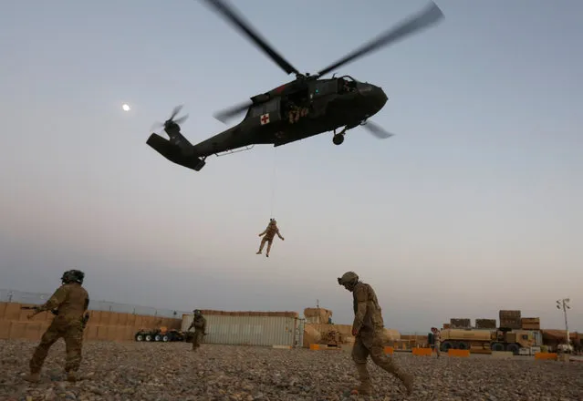 A U.S. Navy Corpsman and U.S. soldier take part in a helicopter Medevac exercise in Helmand province, Afghanistan, July 6, 2017. (Photo by Omar Sobhani/Reuters)