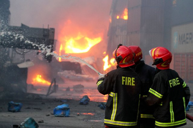 Firefighters try to extinguish a fire that broke out at a container storage facility in Sitakunda, about 40 km (25 miles) from the key port of Chittagong on June 5, 2022. At least 16 people were killed and 170 others injured after a massive fire tore through a container depot in southern Bangladesh, officials said on June 5. (Photo by AFP Photo/Stringer)