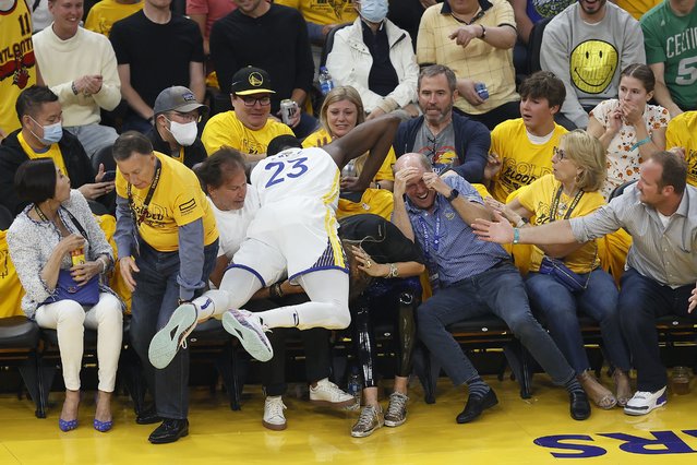Golden State Warriors forward Draymond Green (23) falls into a row of fans during the first half of Game 5 of basketball's NBA Finals against the Boston Celtics in San Francisco, Monday, June 13, 2022. (Photo by John Hefti/AP Photo)