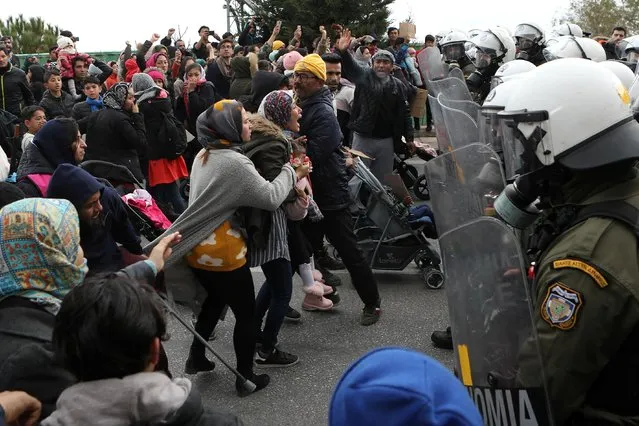 A woman holding a child (C) shouts as refugees and migrants confront riot police during a demonstration outside the Kara Tepe camp, on the island of Lesbos, Greece, February 3, 2020. (Photo by Elias Marcou/Reuters)