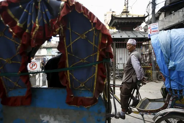 A rickshaw driver waits for passengers during a general strike organised by a 30-party alliance led by a hardline faction of former Maoist rebels, who are protesting against the draft of the new constitution, in Kathmandu, Nepal August 16, 2015. (Photo by Navesh Chitrakar/Reuters)