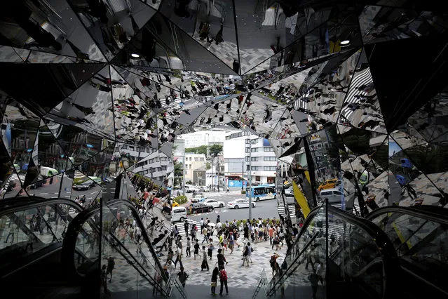 Pedestrians are reflected in mirrors at the entrance of a shopping mall in Tokyo, Japan, 26 June 2015. (Photo by Kiyoshi Ota/EPA)