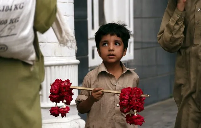 A child sells fresh flowers on a street in Peshawar, Pakistan, August 11, 2015. (Photo by Khuram Parvez/Reuters)