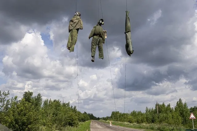 Dummies depicting Russian soldiers are seen hanging near the frontline in the Kharkiv region, Ukraine, Saturday, July 23, 2022. (Photo by Evgeniy Maloletka/AP Photo)