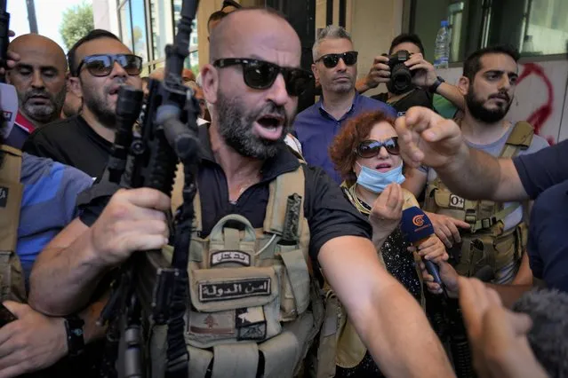 Lebanese State Security forces surround Lebanese Judge Ghada Aoun, wearing face mask, as she leaves the entrance of Central Bank following a raid to pursue Central Bank Governor Riad Salameh, who she has charged for corruption in Beirut, Lebanon, Tuesday, July 19, 2022. (Photo by Bilal Hussein/AP Photo)
