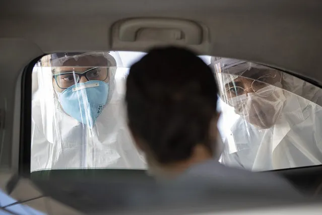 Medical personnel check people inside their cars to find out if they have symptoms of COVID-19 in Guarulhos on the outskirts of Sao Paulo, Brazil, Monday, March 30, 2020. (Photo by Andre Penner/AP Photo)
