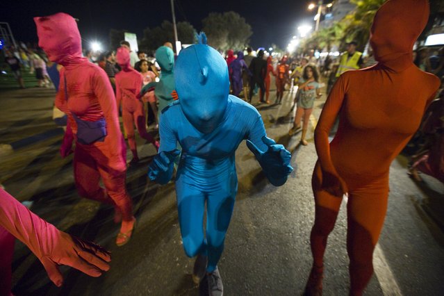 A group of people wearing full solid-coloured bodysuits walk along a promenade as they take part in a street art performance in Bat Yam, near Tel Aviv, Israel August 29, 2015. (Photo by Amir Cohen/Reuters)