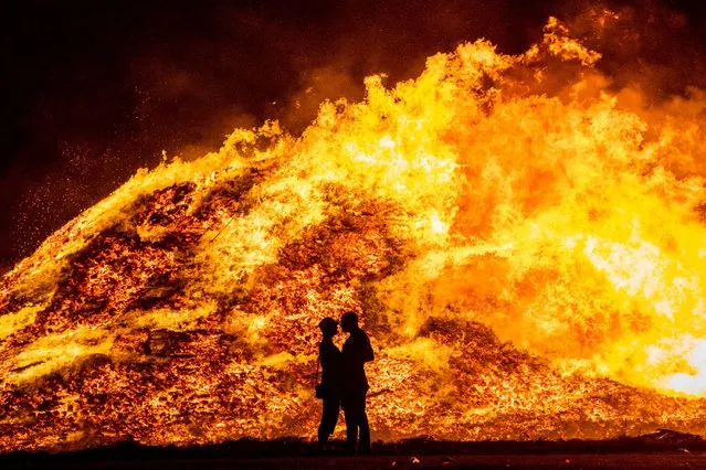 A couple embrace in silhouette at Craigyhill loyalist bonfire in Larne, Co Antrim on Monday July 11, 2022, on the “Eleventh night” to usher in the Twelfth commemorations. (Photo by Liam McBurney/PA Images via Getty Images)