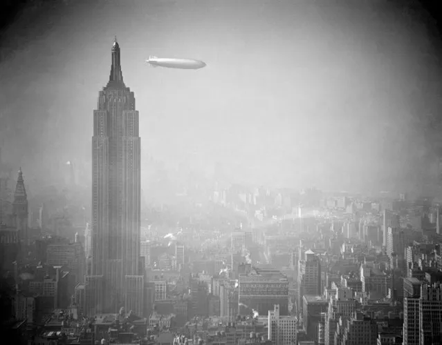 The Zeppelin Hindenburg floats in a hazy sky near the Empire State Building over Manhattan, August 8, 1938. The German airship is en route to Lakehurst, N.J. from Germany. (Photo by AP Photo)