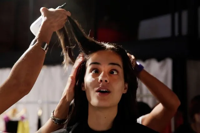 Brazilian model Maira, 19, of Rio de Janeiro, crosses her eyes for the photographer as her hair is styled backstage before modeling in the Tracy Reese Spring 2015 collection show Sunday, September 7, 2014, during Fashion Week in New York. Maira said she was discovered during a supermodel contest in Brazil at age 14 and is modeling in her first New York Fashion Week this season. (Photo by Richard Drew/AP Photo)