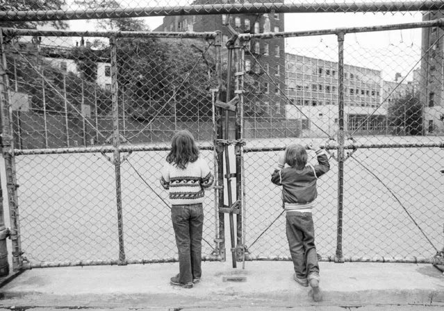 Susannah Scranton, 6, left, and Morgan Phillips, 6, students at P.S. 41 in New York's Greenwich Village, stand before the locked gates to their school's playground, September 11, 1975, which is closed along with the school because of the teachers' strike. The walkout, the largest in the nation, is in its third day. (Photo by Suzanne Vlamis/AP Photo)