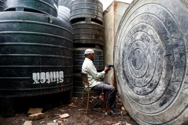 A man repairs a water tank at a workshop in Mumbai, India, August 11, 2016. (Photo by Danish Siddiqui/Reuters)