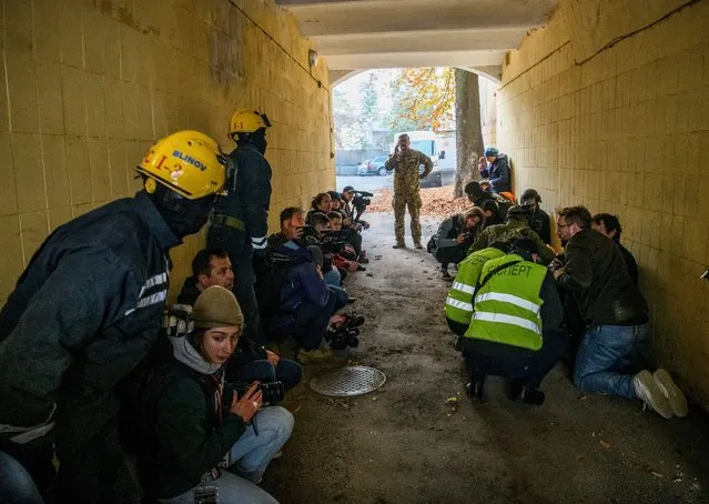 Rescued people, journalists and police officers take cover as an air-raid siren sounds during a Russian drone strike, which local authorities consider to be Iranian-made unmanned aerial vehicles (UAVs) Shahed-136, amid Russia's attack on Ukraine, in Kyiv, Ukraine on October 17, 2022. (Photo by Vladyslav Musiienko/Reuters)