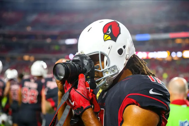 Arizona Cardinals quarterback Larry Fitzgerald takes a photo with a fans Canon camera on the sidelines prior to the game against the Seattle Seahawks at University of Phoenix Stadium on November 9, 2017 in Glendale, AZ, USA. (Photo by Mark J. Rebilas/Reuters/USA TODAY Sports)