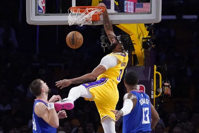 Los Angeles Lakers forward Anthony Davis, center, dunks as Los Angeles Clippers center Ivica Zubac, left, and guard Paul George defend during the first half of an NBA basketball game Thursday, October 20, 2022, in Los Angeles. (Photo by Mark J. Terrill/AP Photo)