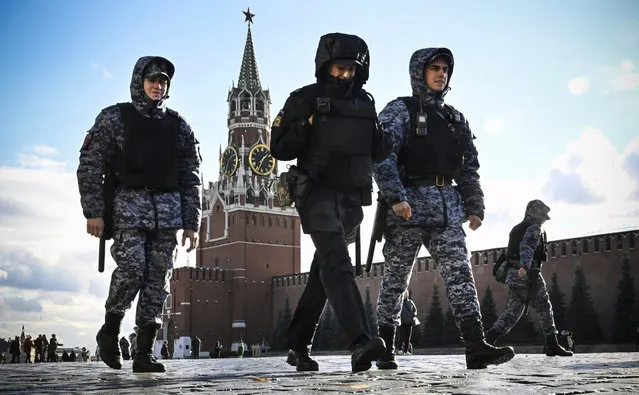 Police and the Russian National Guard (Rosgvardia) servicemen patrol Red Square in front of the Spasskaya tower of the Kremlin in Moscow on October 24, 2022, as part of security reinforcement measures. (Photo by Alexander Nemenov/AFP Photo)