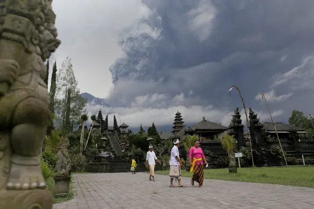 Balinese Hindus walk after praying as Mount Agung volcano erupts at Besakih Temple in Karangasem, Bali, Indonesia on November 26, 2017. (Photo by Johannes P. Christo/Reuters)