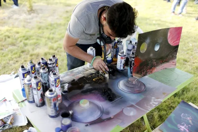 A man spray-paints during a festival commemorating the International Day of Peace in Baghdad, September 21, 2015. (Photo by Thaier al-Sudani/Reuters)