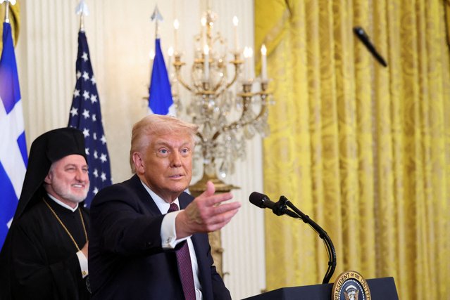U.S. President Donald Trump throws a pen to the crowd, next to Archbishop Elpidophoros of America, during the Greek Independence Day celebration at the White House in Washington on March 24, 2025. (Photo by Kevin Lamarque/Reuters)