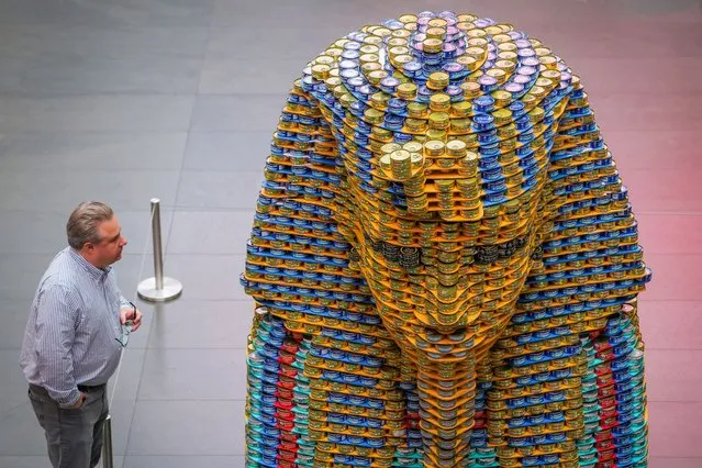 A person looks at a giant sculpture depicting the funerary mask of the pharaoh Tutankhamun, titled “A Meal Fit for a King” and created by Microdesk, Inc. made out of 8,300 cans of tuna which will be donated to local food banks as part of the Canstruction exhibition in Manhattan, New York City, U.S., November 11, 2022. (Photo by Andrew Kelly/Reuters)