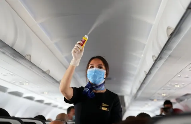 A flight attendant wearing a face mask sprays disinfectant inside a plane at Sharm el-Sheikh International Airport, following the outbreak of the coronavirus disease (COVID-19), in Sharm el-Sheikh, Egypt, June 20, 2020. (Photo by Mohamed Abd El Ghany/Reuters)