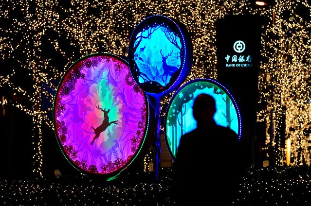 A man walks past Christmas decorations outside China World Trade Center Tower III in Beijing, China December 17, 2017. (Photo by Jason Lee/Reuters)