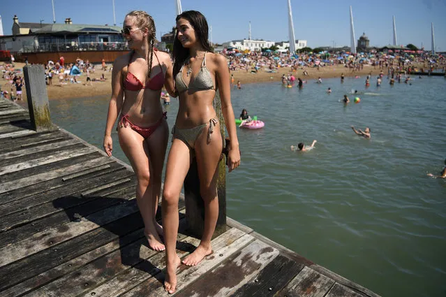 Women pose as they are photographed at Southend Beach, Britain, 31 July 2020. The Met Office has predicted 31 July to be the hottest day of the year so far with temperatures possibly 35C in Greater London, according to media reports. (Photo by Neil Hall/EPA/EFE)