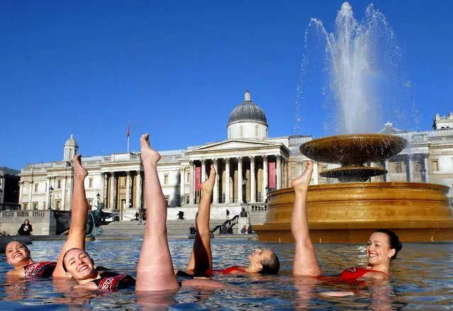 Synchronised swimmers attempt to achieve a Guinness World Record for “the most ballet leg switches in one minute” in a fountain in Trafalgar Square in London, November 9, 2006. November 9 marked the second annual Guinness World Records Day, an international effort that sees hopefuls across the world attempt to break their very own record. (Photo by Bertrand Langlois/AFP Photo)