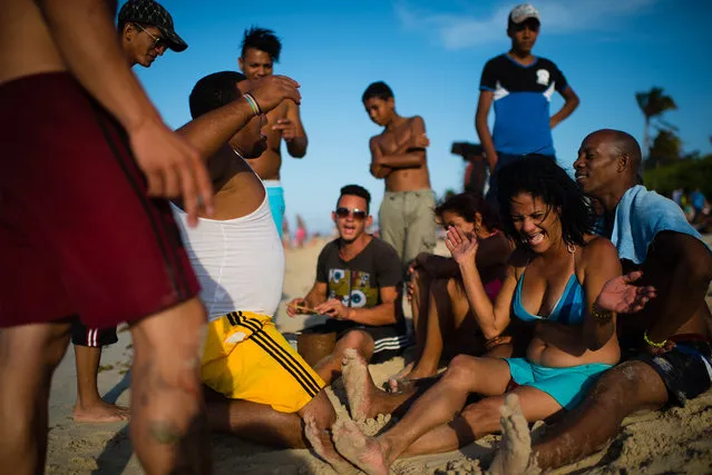 A group of Cubans use tin cans, sticks and their voices to make amazing music on the shore of Santa Maria beach, about 15 miles from Havana. It is the closest beach to Havana. The government is demolishing buildings all over the coast of East Havana and recovering and restoring beach dunes. (Photo by Sarah L. Voisin/The Washington Post)