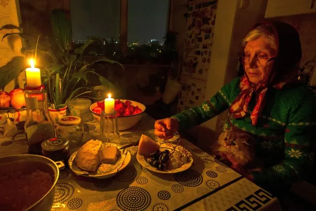 A woman eats her dinner by candle light during a reducing of energy consumption plan in the residential area of Chisinau, Moldova, 25 October 2022. Moldova faces an energy crisis as gas prices for Moldova grew in October to 1028 US dollars per thousand cubic meters after attacks on Ukrainian power supply sources. Moldovans have been asked to save electricity and gas. (Photo by Dumitru Doru/EPA/EFE)