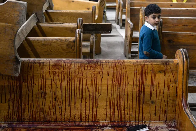 A little boy stands next to a blood splattered church bench at the scene of a bomb explosion inside Mar Girgis church in Tanta, 90km north of Cairo, Egypt, 09 April 2017. (Photo by Mohamed Hossam/EPA/EFE)