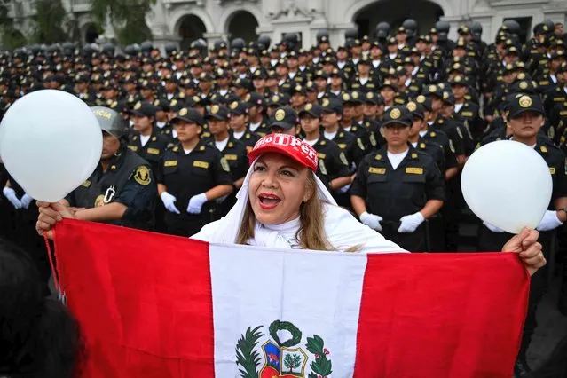 A woman takes part in a march to ask for peace and in support of the police and military at the San Martin square in Lima, on December 16, 2022. Peru declared a nationwide state of emergency on December 14 over violent protests against the ouster and arrest of ex-president Pedro Castillo that have left seven people dead. Peru's Supreme Court on the eve ordered ousted president Pedro Castillo to remain in detention for another 18 months after his arrest last week. (Photo by Martin Bernetti/AFP Photo)
