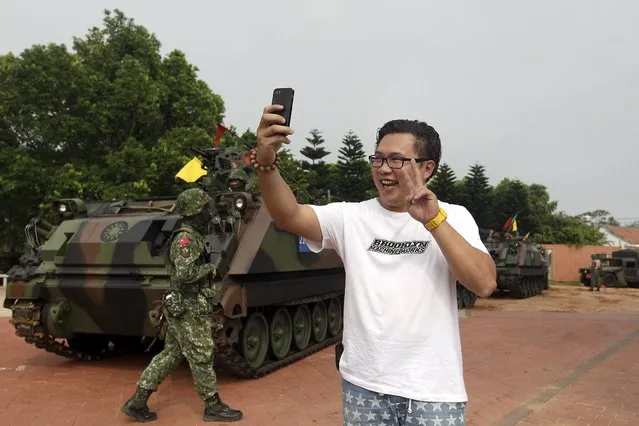A local resident takes a selfie with his smartphone in front of military soldiers and tanks during the annual Han Kuang military exercise in Kinmen, Taiwan, September 7, 2015. (Photo by Pichi Chuang/Reuters)