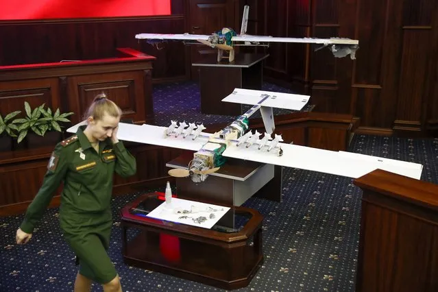 A Russian officer walks next to drones that attacked the Russian air base in Syria and were captured by the Russian military are displayed at a briefing in the Russian Defense Ministry in Moscow, Russia, Thursday, January 11, 2018. Saturday's, Jan.6, 2018 raid against the Hemeimeem air base and a Russian naval facility in Tartus involved 13 drones, seven of the drones were shot down by air defense systems and the remaining six were forced to land, according to the Russian Defense Ministry. (Photo by Pavel Golovkin/AP Photo)
