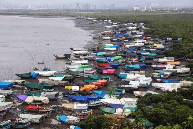 Anchored fishing boats are covered with tarpaulins as the fishing season comes to an end near the Arabian Sea shore at the Chowk Dongri village, on the outskirts of Mumbai, India, 03 June 2025. Local fishermen stop fishing between 01 June and 31 July during the monsoon season due to expected rough seas, uncertain wind conditions, and continuous rain, which could cause severe damage to the boats. (Photo by Divyakant Solanki/EPA/EFE)