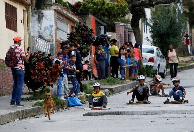 Children participate in a traditional street race with wooden makeshift carts called “carruchas”, in Caracas, Venezuela on December 17, 2022. (Photo by Leonardo Fernandez Viloria/Reuters)