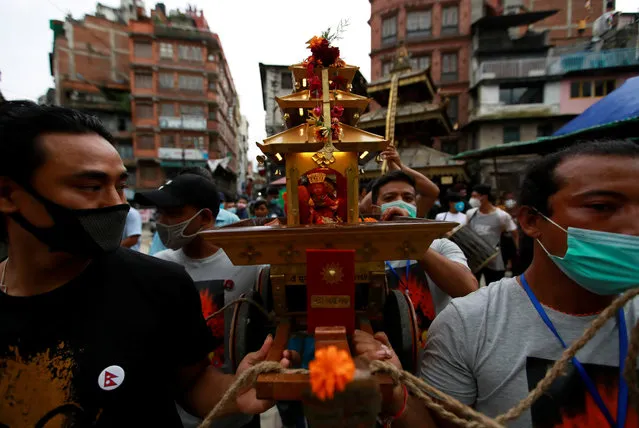 People carry the miniature chariot of the Living Goddess Kumari during the annual festival of Indra Jatra as official celebration has been cancelled due to the spread of the coronavirus disease (COVID-19) in Kathmandu, Nepal on September 2, 2020. (Photo by Navesh Chitrakar/Reuters)
